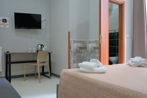 Superior King Room at Royal Rooms Station Napoli with bed, desk, flat-screen TV, and modern amenities in Naples, Italy