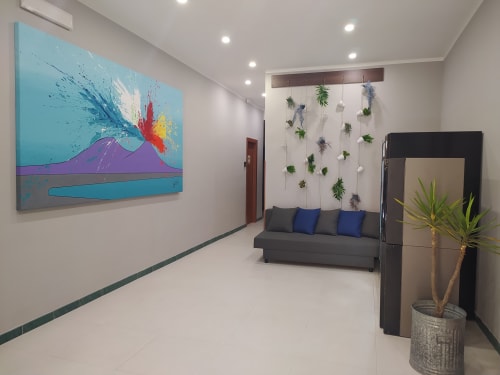 Modern small double room at Royal Rooms Station Napoli with colorful volcano artwork, gray sofa, hanging plants, and city
