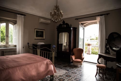 Camera elegante al B&B Valle Allegra di Gravina di Catania con letto rosa, lampadario in cristallo e vista sulle montagne