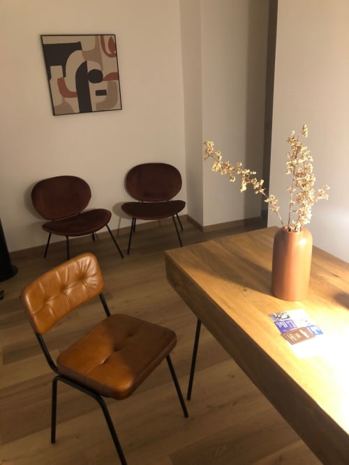 Modern lounge area at Maison Vaticana Guest House Rome with leather chairs, wooden table, dried flowers, and contemporary