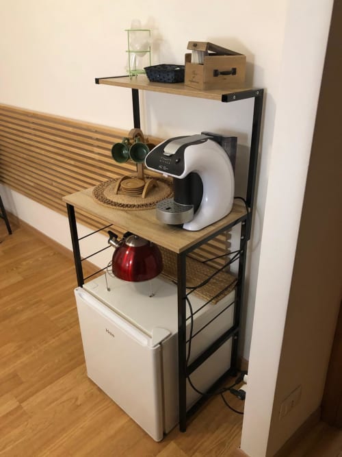 Kitchen corner at Maison Vaticana Guest House Rome with shelving, coffee maker, kettle, and mini refrigerator