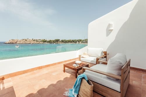 Terraza frente al mar en Las Golondrinas con tumbonas, muebles de madera y vistas turquesas del Mediterráneo en Cap d'Artrutx