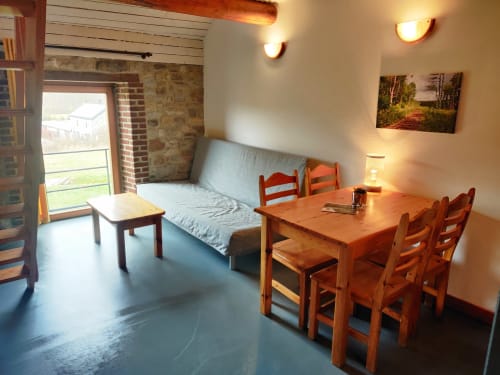 Cozy apartment at La Ferme De Werpin with dining table, sofa bed, and garden view in Hotton