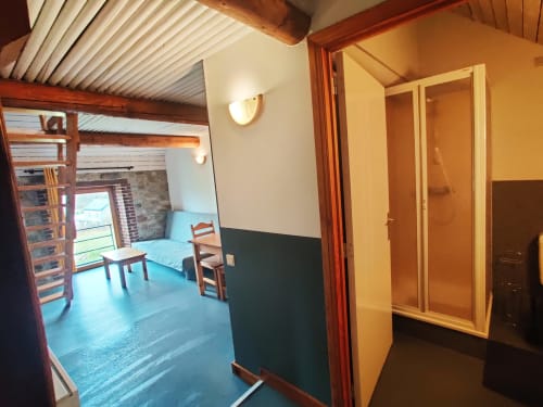 La Ferme De Werpin apartment entryway with blue floor, shower room, and garden-view bedroom in Hotton