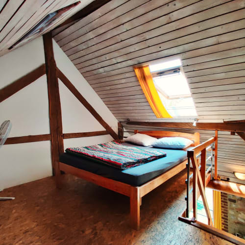Cozy attic bedroom at La Ferme De Werpin with wooden beams, double bed, and skylight window in Hotton