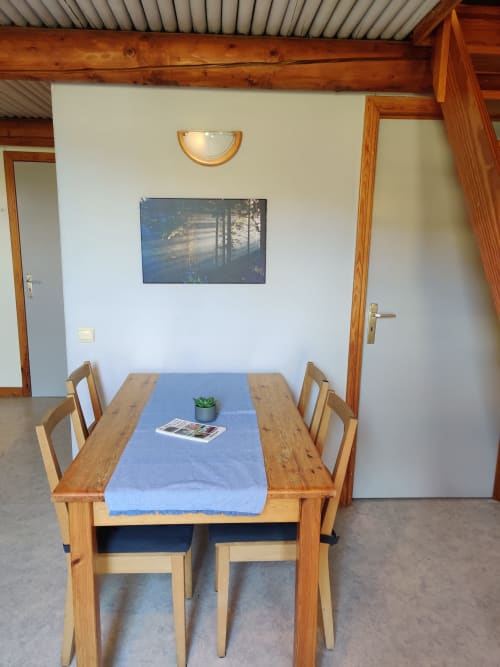 Salle à manger de l'appartement vue montagne à La Ferme De Werpin, Hotton avec table en bois, chaises et nappe bleue
