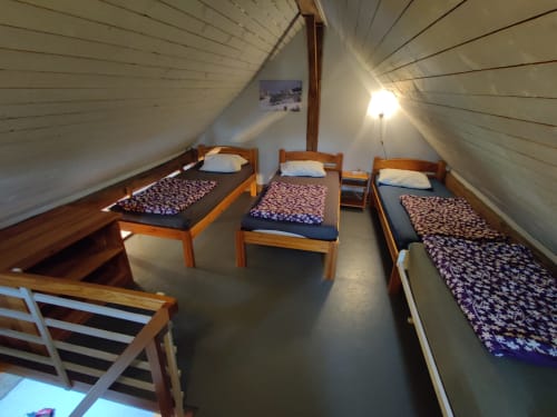 Chambre mansardée avec trois lits en bois et matelas à motifs à La Ferme De Werpin, Hotton Belgique