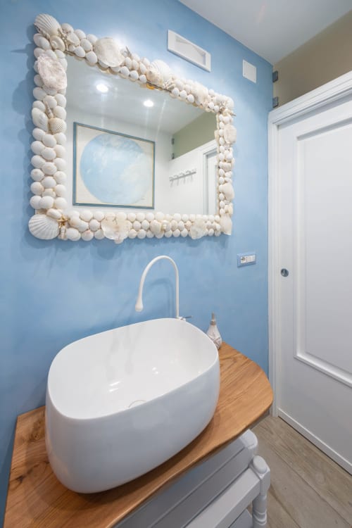 Bagno costiero di Villa Costanza sulla Costiera Amalfitana, con pareti blu, specchio decorato a conchiglie e moderno lavabo ovale bianco, Maiori