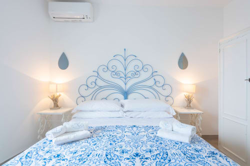 Camera da letto blu e bianca di Villa Costanza sulla Costiera Amalfitana a Maiori con testata ornamentale e servizi moderni