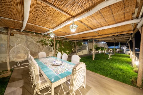 Zona pranzo esterna di Villa Costanza con soffitto intrecciato, arredi bianchi e vista mare a Maiori, Costiera Amalfitana