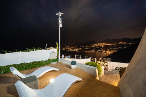 Terrazza Villa Costanza di notte con lettini che si affacciano sulla costa illuminata di Maiori, Costiera Amalfitana
