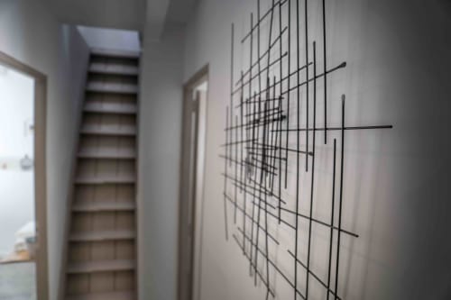 Modern hallway at Mas Lafleur with geometric wall art, wooden stairs, and minimalist decor in Châteaurenard