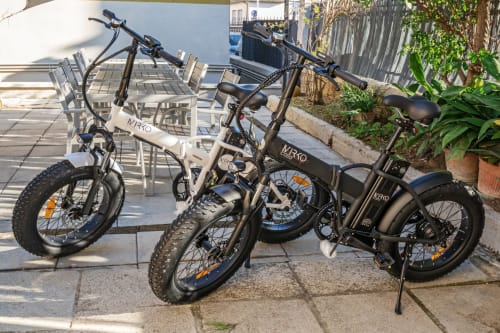 Bici elettriche da fuoristrada parcheggiate nel patio di Casa Mirko B&B ad Arezzo, vicino a sedute esterne e piante da giardino.