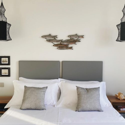 Camera con tema costiero presso B&B Dimora Vistamare a Barletta, testata imbottita grigia, biancheria bianca, decori a forma di pesce