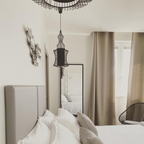 Camera classica a B&B Dimora Vistamare a Barletta con letto imbottito, lampada a sospensione, specchio e accesso al balcone con vista mare