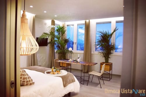 Camera Deluxe con vista mare presso Dimora Vistamare B&B a Barletta con letto, scrivania, piante e lampada a sospensione