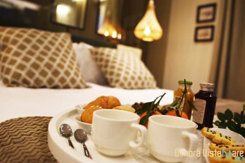 Vassoio colazione in Camera Deluxe di B&B Dimora Vistamare, Barletta con tazze di caffè, pasticceria e letto con vista mare