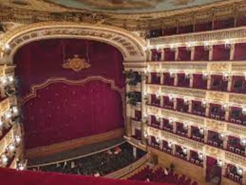 Interno del grand teatro dell'opera con sedili in velluto rosso e balconate ornate a Napoli, Italia