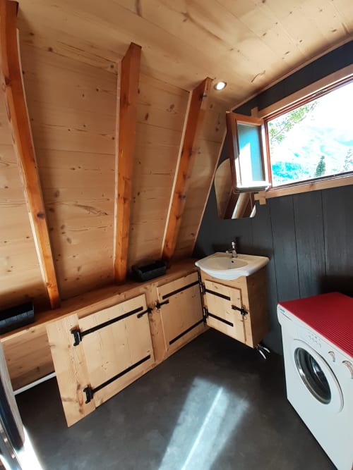 Salle de bains moderne du Chalet Cocody Norvégien aux Chalets Cocody, Jausiers, avec meuble-lavabo en bois, lavabo, machine à laver et