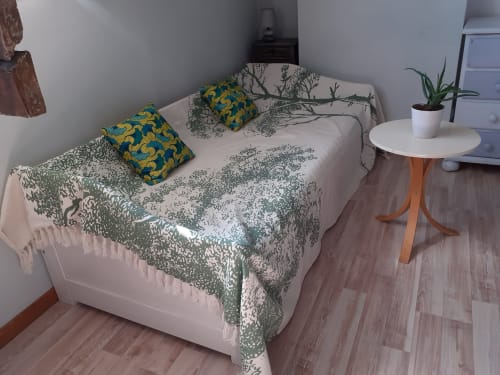 Chambre cosy au refuge des Alpes mancelles avec literie botanique, coussins décorés et table de nuit en bois garnie d'une plante