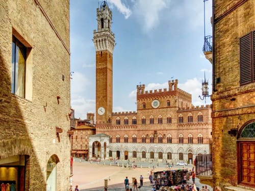 Piazza medievale storica con torre e edifici in mattoni vicino a Pomarance