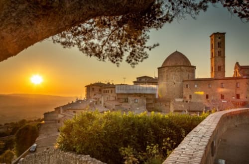 Tramonto sul villaggio di Pomarance con chiesa storica, campanile e paesaggio toscano presso Agri-Bio Santa Palmira