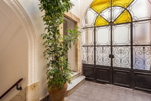 Elegante corridoio delle Sicilianinsta Rooms a Catania con finestra in ferro battuto ornamentale e rampicante