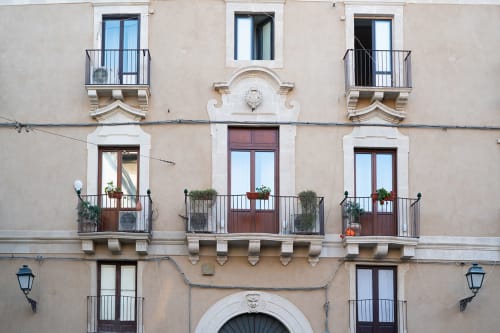 Facciata storica dell'edificio Sicilianinsta Rooms a Catania con finestre ad arco, balconate in ferro e vasi di piante