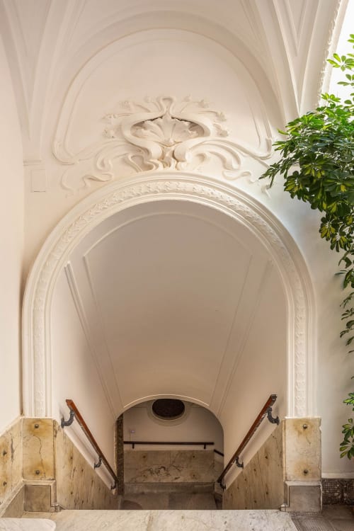 Elegante corridoio ad arco con ornamenti in stucco e balaustre in legno alle Sicilianinsta Rooms di Catania