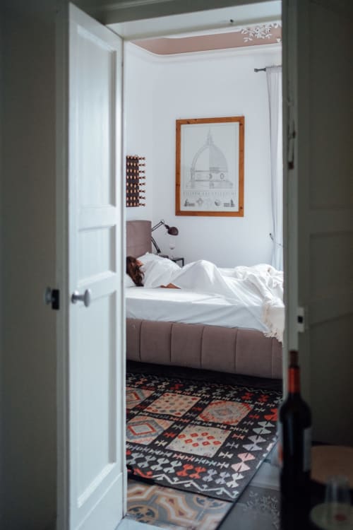 Camera accogliente di Sicilianinsta Rooms a Catania con pareti bianche, letto in pelle marrone e decorativo affresco a cupola