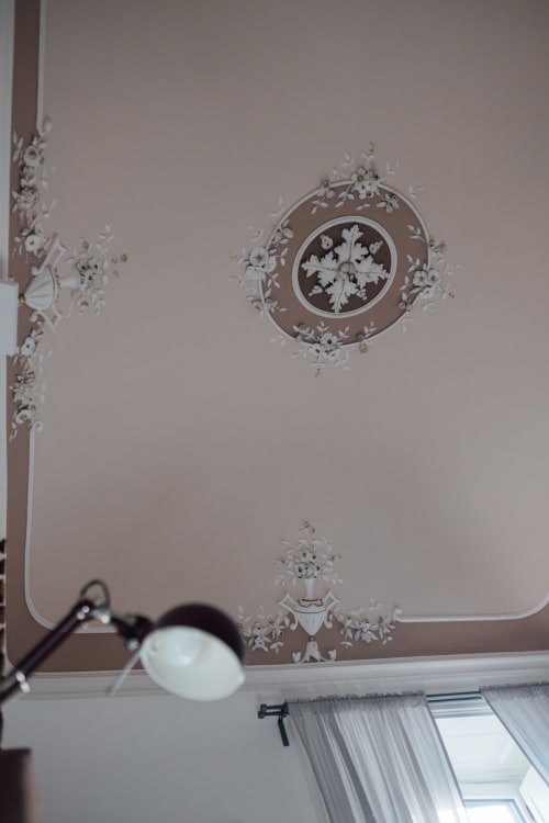Elegante rosone decorativo con rilievi floreali e crocifisso nella raffinata suite di Catania presso Sicilianinsta Rooms