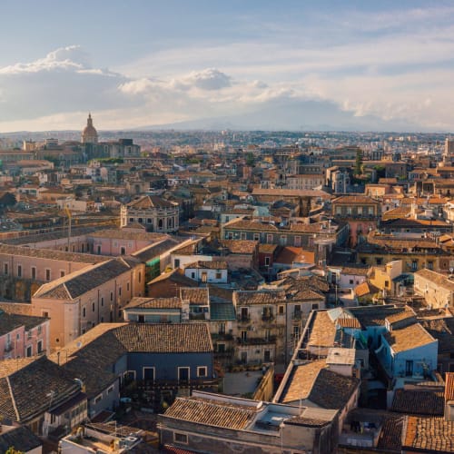 Vista aerea dei tetti storici di Catania con edifici colorati e la cupola della cattedrale visibile, Sicilia Italia
