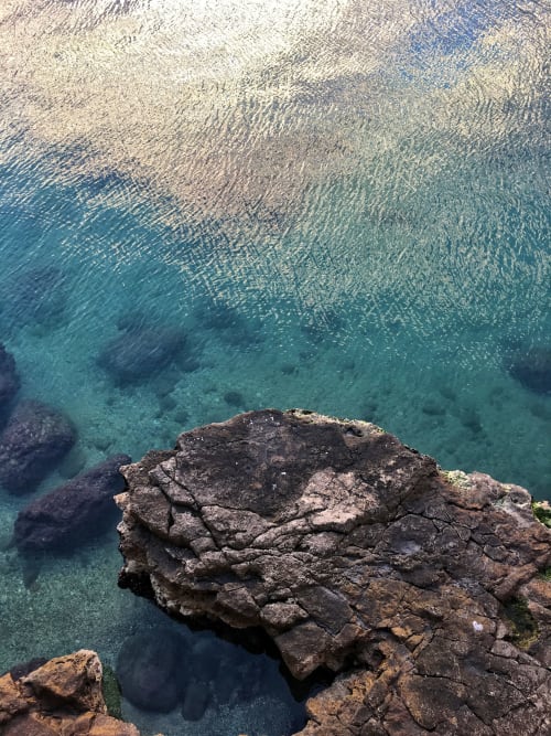 Acque turchesi del Mediterraneo e costa rocciosa presso le Siciliani Rooms a Catania, Italia