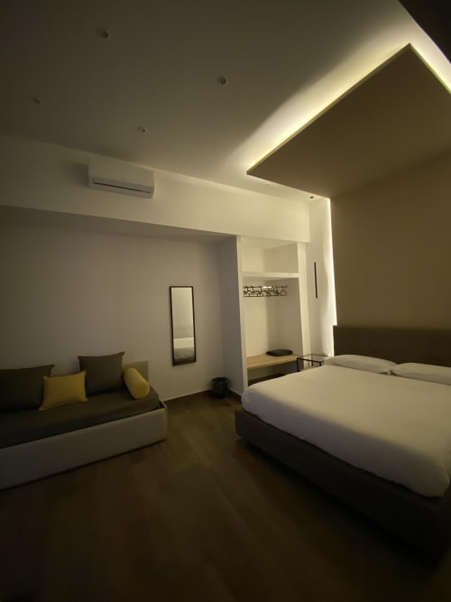 Deluxe-Familienzimmer im Salotto Toledo, luxuriöses B&B in Neapel, mit modernem Bett, Sitzbereich und Deckenambientebeleuchtung