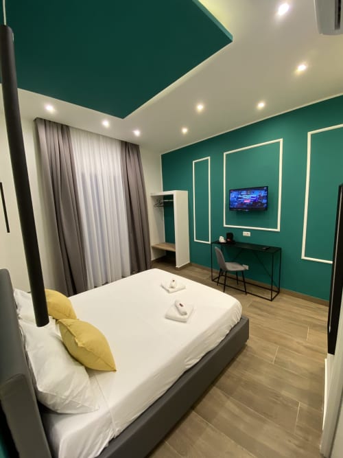 Superiorzimmer im Salotto Toledo Luxury Rooms in Neapel mit blaugrünen Wänden, Queen-Bett, Schreibtisch, TV und modernen Annehmlichkeiten