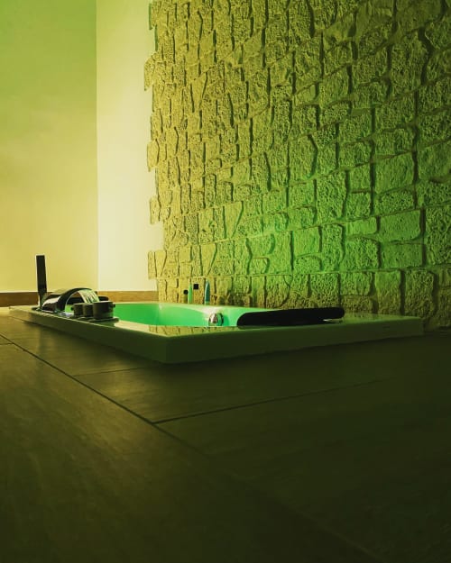 Luxuriöse beleuchtete Jacuzzi-Suite im Salotto Toledo Neapel mit modernen Annehmlichkeiten und strukturierter Akzentwand