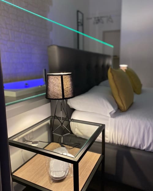Modernes Luxuszimmer im Salotto Toledo Neapel mit Bett, Designerleuchte und cyan Neon-Akzentbeleuchtung