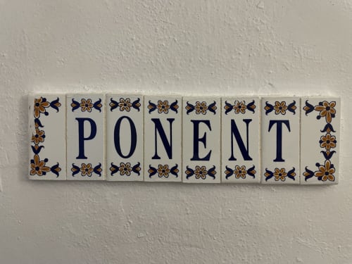 Decorative tiles spelling 'PONENT' with blue and orange floral patterns at Petit Hotel Sa Plana, Estellencs