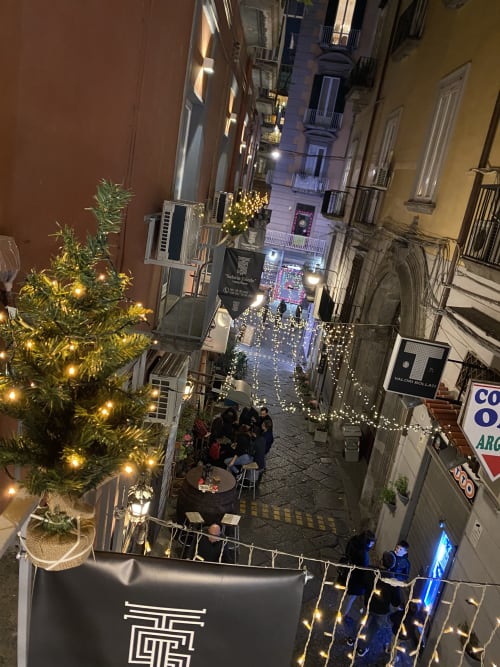 Affascinante vista notturna festiva del vicolo delle camere di lusso Salotto Toledo a Napoli, decorato con luci natalizie e decorazioni verdi
