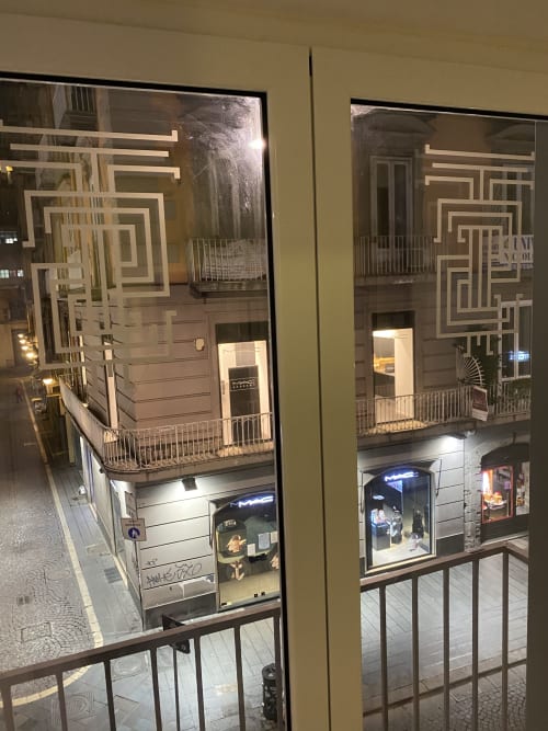 Vista notturna delle lussuose camere Salotto Toledo a Napoli, Italia, con la storica facciata dell'edificio e la vetrina illuminata