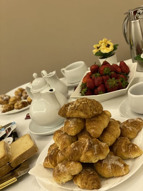 Colazione elegante presso il B&B di lusso Salotto Toledo a Napoli: croissant, fragole fresche, teiera e pasticcini su bianco
