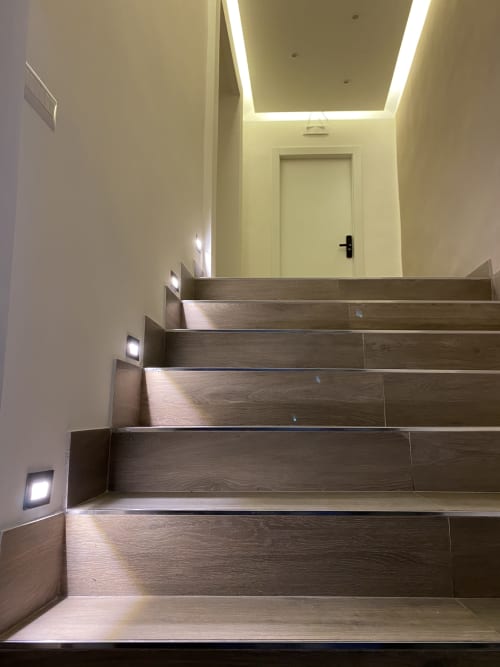 Scala moderna con gradini in legno e illuminazione ambientale presso il Salotto Toledo, camere di lusso a Napoli