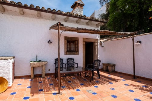 Casa Rural El Fontano rooftop terrace in Montanchez with seating, wooden pergola, and traditional Andalusian tilework