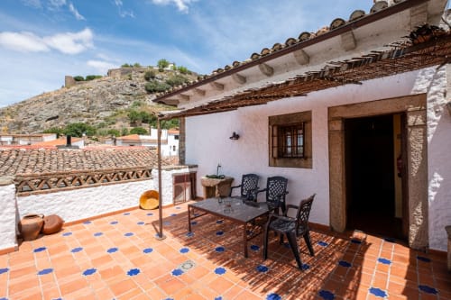 Terracotta tiled patio at Casa Rural El Fontano villa in Montanchez with dining area and mountain views