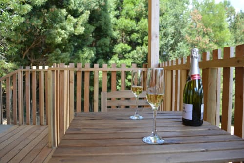 Copas de champagne y vino en terraza de madera de Cabañas Compostela, Santiago de Compostela