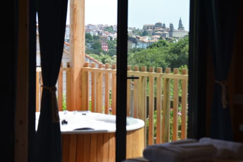 Bañera de hidromasaje en terraza con vistas a la catedral y el skyline de Santiago de Compostela, Cabañas Compostela