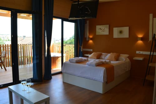 Habitación moderna con terraza en apartamento de Santiago de Compostela, paredes naranjas, camas gemelas, vistas a la ciudad
