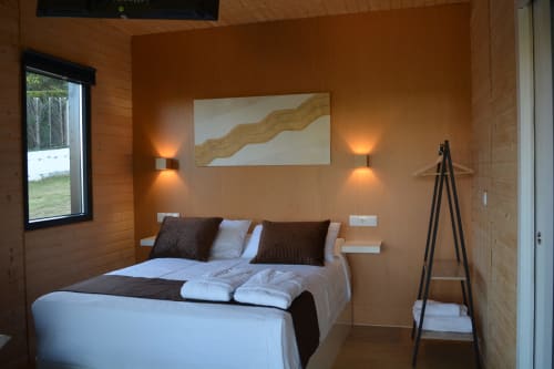 Dormitorio de cabaña moderna con cama queen size, vista a la montaña, iluminación ambiental y mobiliario contemporáneo en Cabañas