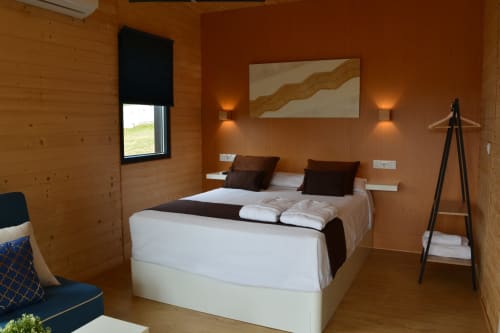 Acogedora habitación de cabaña de madera en Cabañas Compostela con cama queen, ventana con vista a las montañas y comodidades modernas
