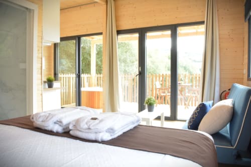 Espacioso dormitorio en Cabaña A Fervenza con vistas a la montaña, interior de madera, acceso a terraza y comodidades modernas